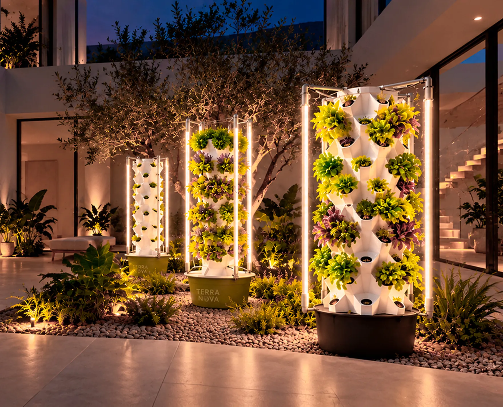 Varias torres de cultivo de TerraNova iluminadas de noche en un patio