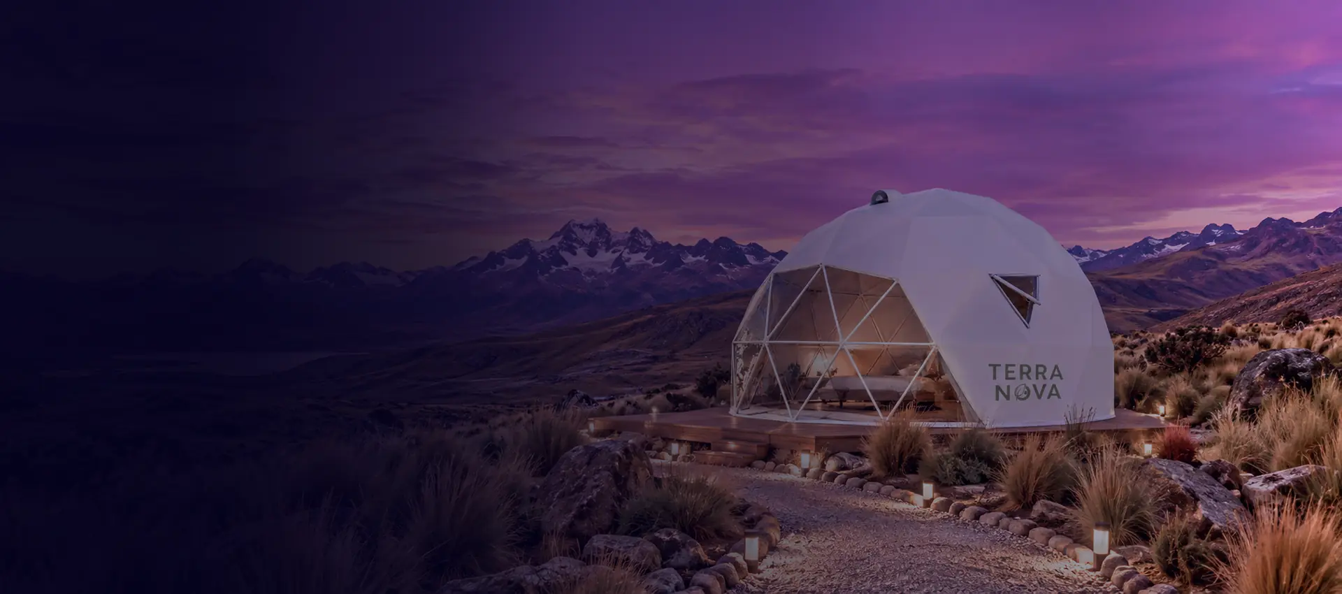 Domo geodésico habitacional entre montañas nevadas al atardecer